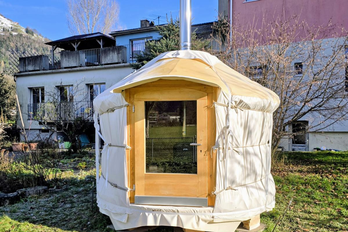 Aussenansicht einer Jurte mit Holzeingang in der Schweiz