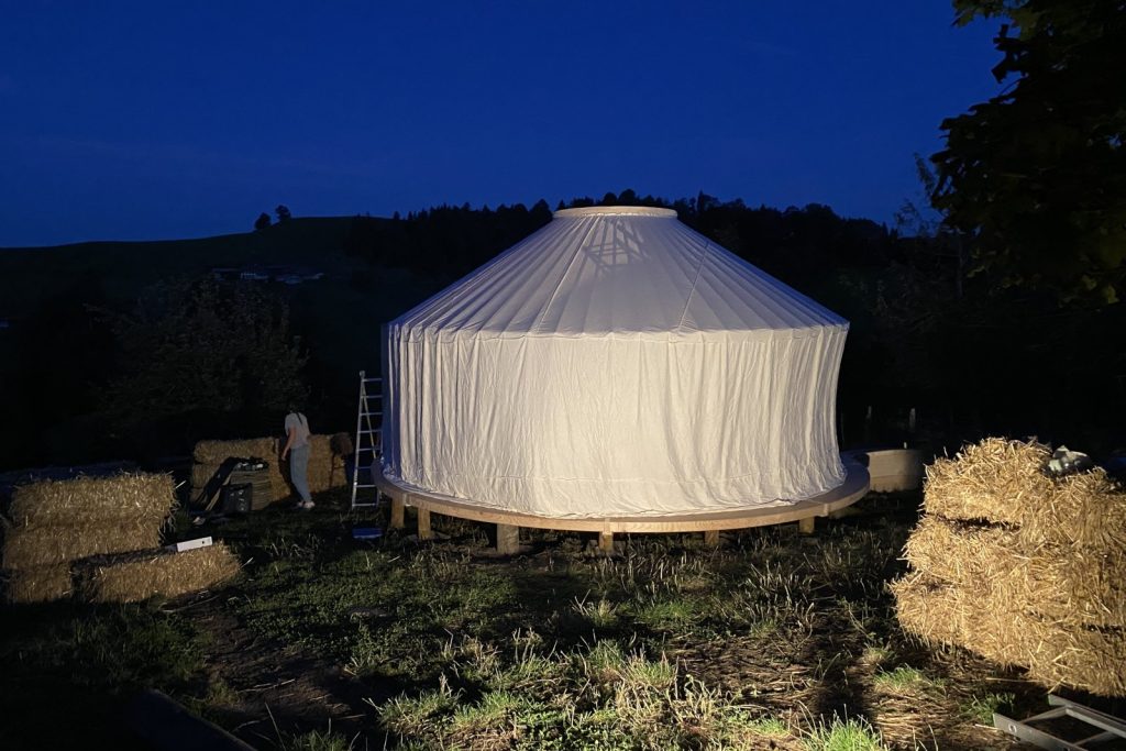 Wohnjurte im Aufbau bei Abendlicht – Jurtenbau Schweiz
