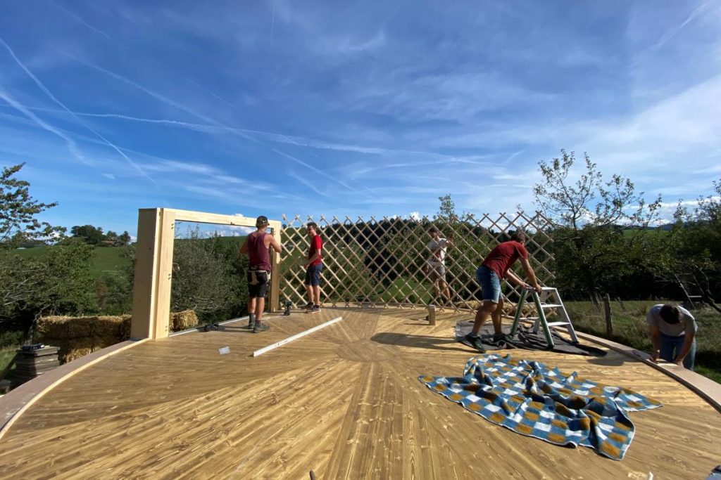 Aufbau einer Jurte – Holzgitterkonstruktion auf vorbereiteter Bodenplattform
