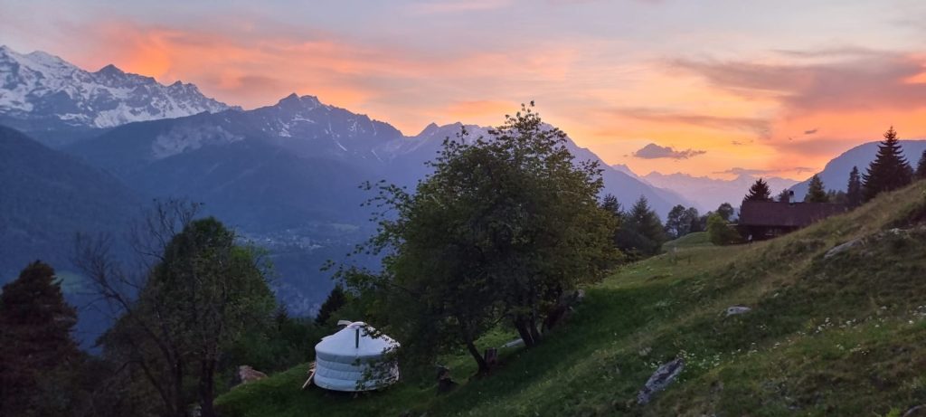 Handgefertigte Wohnjurte in der Schweizer Berglandschaft bei Sonnenuntergang.