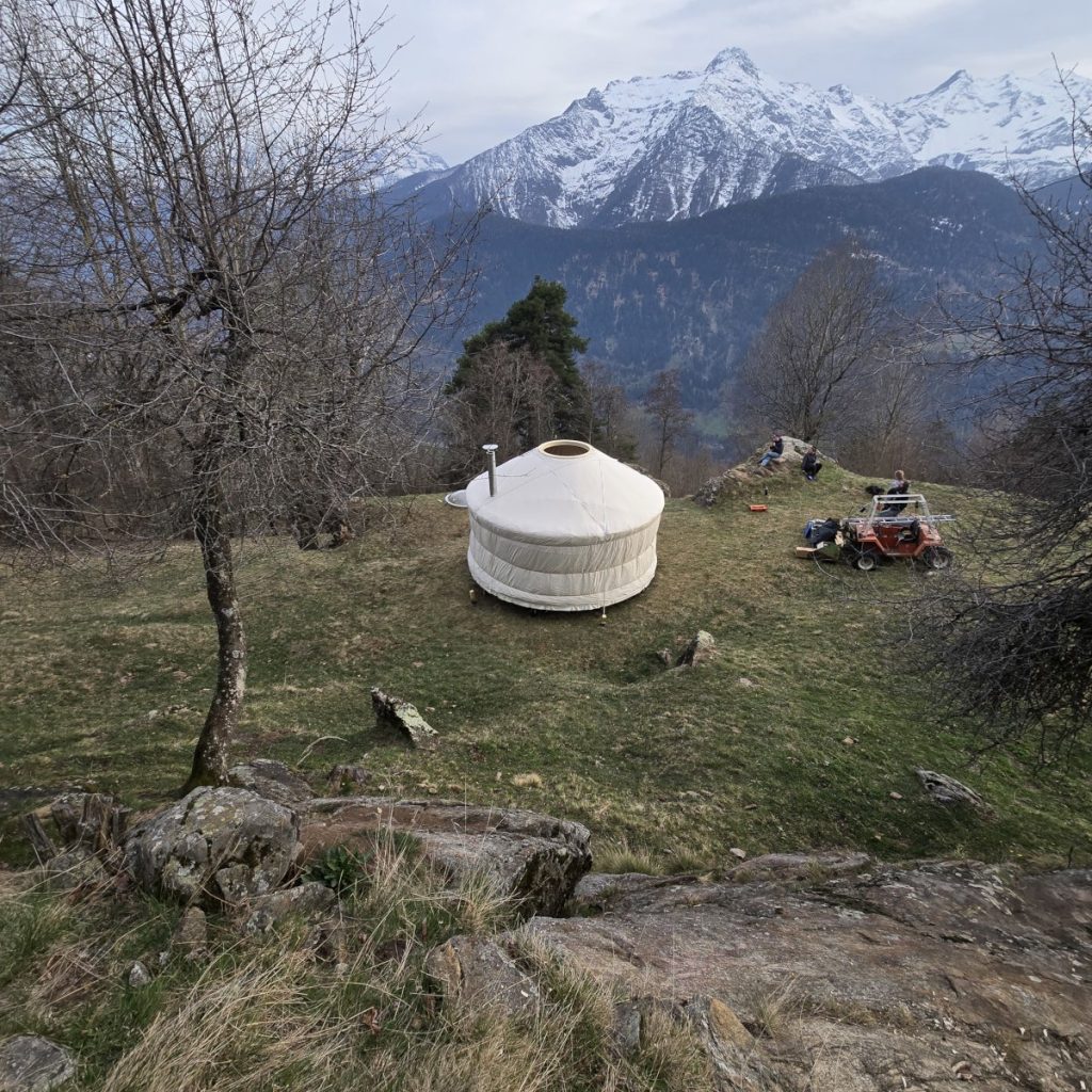 Fertige handgefertigte Wohnjurte in der Schweizer Berglandschaft.