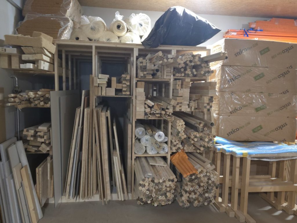 Materiallager mit Holz, Rundstäben und Stoffen in der Werkstatt von Holzhandwerk Montagen in Amsteg (Uri).